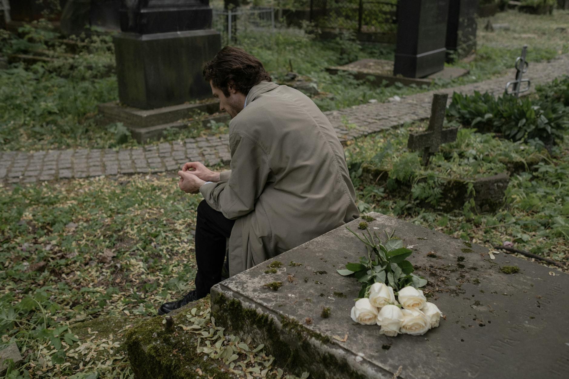 a man sitting by a grave