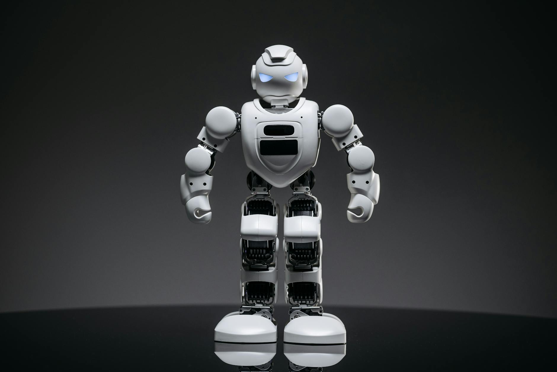 a close up shot of a white robot toy with lighted eyes