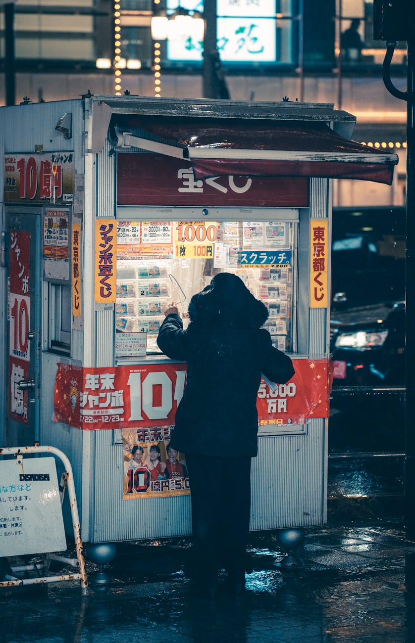 person buying a lottery ticket in a booth